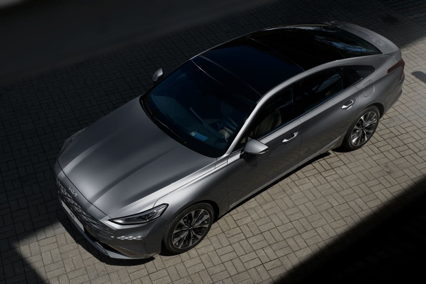 Gray midsize sedan seen from above on a paved lot, similar to a Chevrolet Malibu